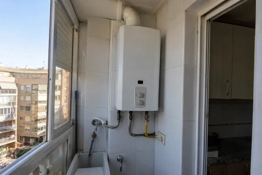 Calentador de gas para agua caliente instalado en una galería con azulejos